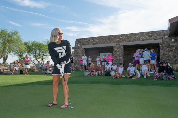 Renee Parsons in PXG Apparel, putting while a gathering of people watch