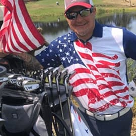 Man wearing American flag polo posing on the golf course.