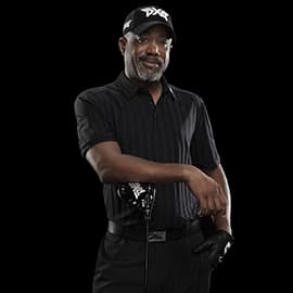Headshot of Darius Rucker with a PXG golf bag on a black background
